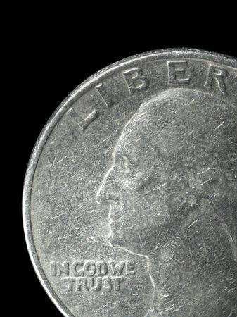 Closeup of a US Quarter on a black background with the inscription "IN GOD WE TRUST" prominently visible in the lower left.の写真素材
