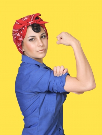 Classic World War II poster featuring Rosie the Riveter flexing her arm muscles against a yellow background.の写真素材