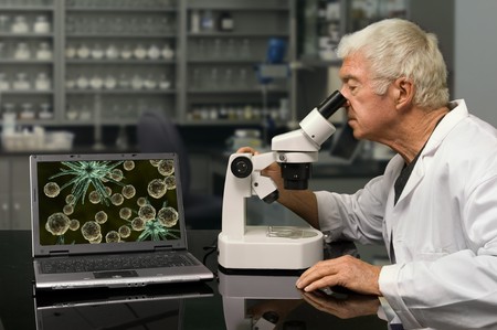 Biologist looking through a microscope in a research labの写真素材