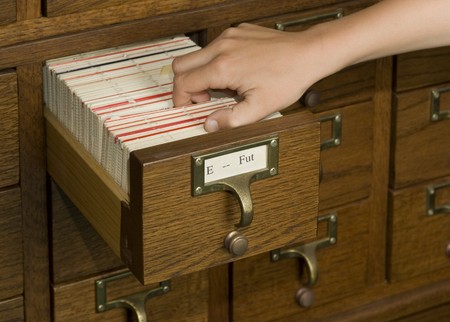 Hand reaching into a card catalog file drawerの写真素材