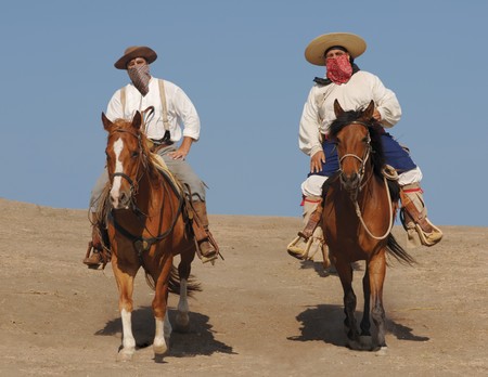 Two banditos riding on horsesの写真素材