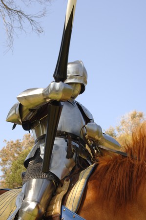 Medium shot of a 15th century English knight in full armour holding a lance on horsebackの写真素材