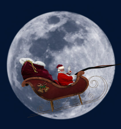 Santa flying in his sleigh against a full moon backgroundの写真素材