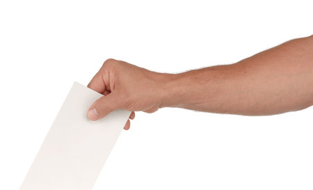 A man's hand putting an envelope in a slot