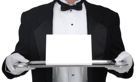 Butler in tuxedo presenting a blank card on a silver tray