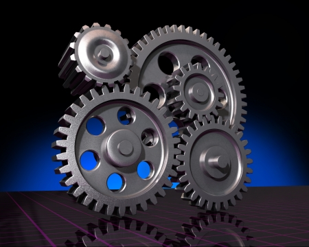 Five machine gears on a reflective surface and a dark backgroundの写真素材