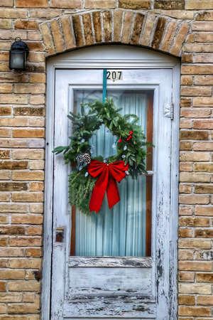 Distressed door decorated with a Christmas wreathの写真素材
