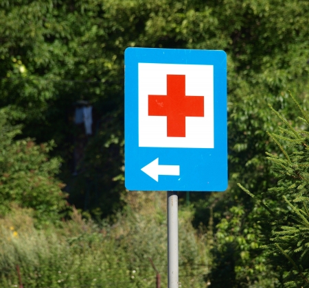 Kazimierz Dolny, Poland - July 27, 2008 - Hospital sign with red cross and arrow on streetのeditorial素材
