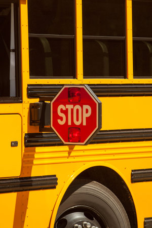 Yellow school bus stop sign up close view.