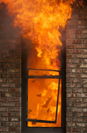 A house burns with flames shooting out the window.