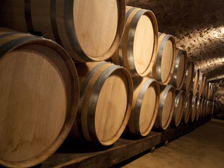 Aging wine in oak barrels at a winery in a wine cellar.の写真素材