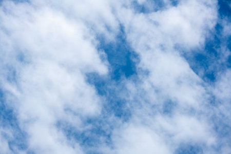 Blue sky background with bright white clouds.