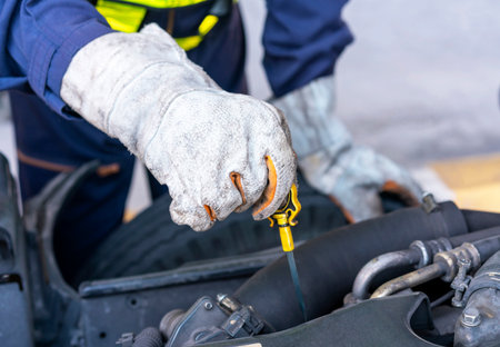 Closeup of mechanic's hands checking oil engine. Technician inspecting and maintaining engine of truck, car or vehicle. Mechanic man car service repair automobile vehicles service mechanical man engineering.の写真素材