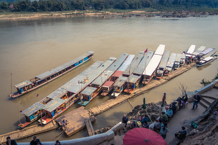 Boats taking tourists to the buddha cave on the Mekong river near Luang Prabangのeditorial素材