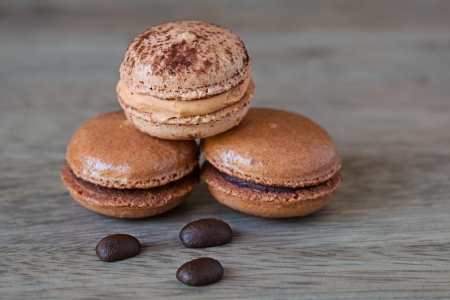 French Chocolate   Coffee Macaroons And Coffee Beans, Tasty Gormet Meringue Cookie Sandwich Cake on Vintage Wood Background の写真素材