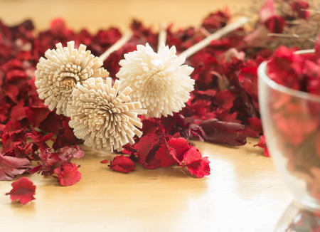 Brown Dried flowers in the red leaf on a wooden plates backgroundの写真素材