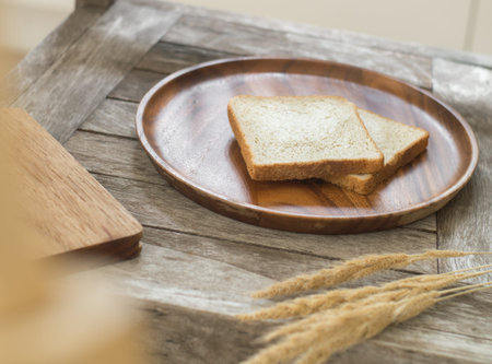 Toast bread on wooden plate and wooden breadboard on wood background