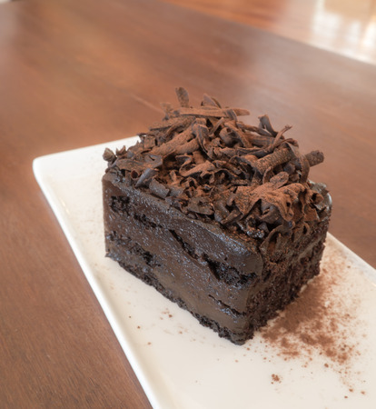 Chocolate cake in white plate on wooden backgroundの写真素材