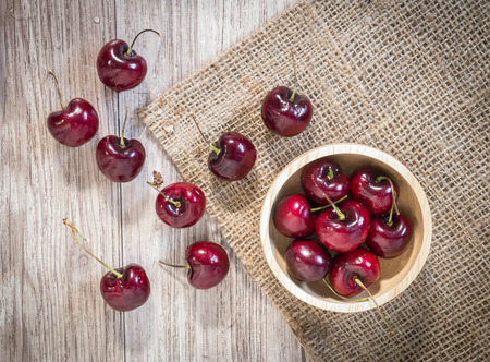 Top view of  Fresh red cherries with water drops on wooden tableの写真素材