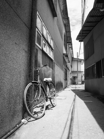 bicycle lean on a wall in street of old town ( black and white tone )の写真素材