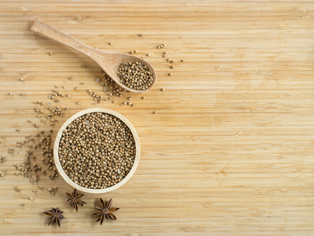Coriander seeds in wooden bowl  and on wooden board.( Space and composition for text )の写真素材