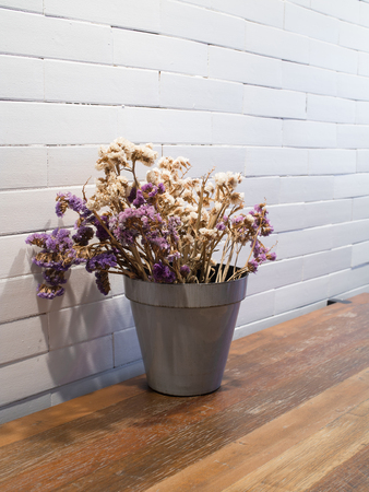 dried flowers in flowerpot  on wooden tableの写真素材