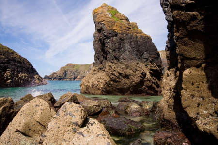 Surf splashing on rocks at kynance coveの写真素材