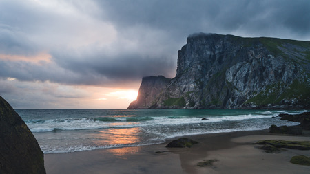 sunset at a beautiful beach in a bay surrounded by high cliffs and mountains. Kvalvika Beach, Lofoten islands, Norway, Scandinaviaの写真素材
