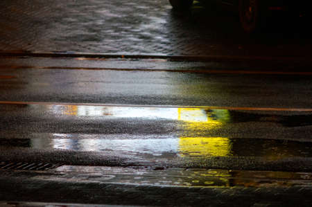 rain on asphlat at night. Rain drops in a puddle. cityの写真素材