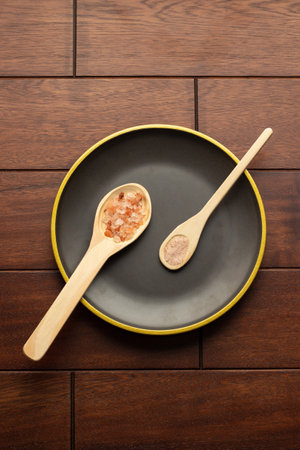pink himalayan salt in spoons and black plateの写真素材