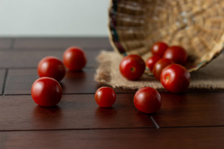 Cherry tomatoes on plate and wood background - Solanum lycopersicum var. cerasiformの写真素材