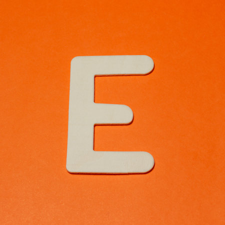 Uppercase letter E - wood texture - Orange backgroundの写真素材