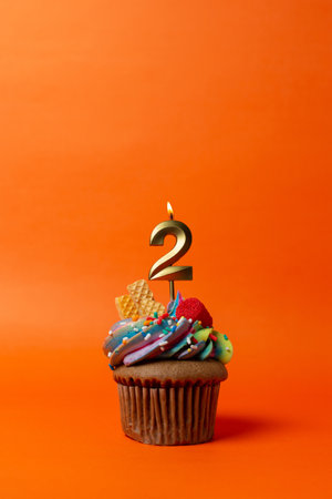 birthday cake with number - cupcake on orange background with birthday candlesの写真素材
