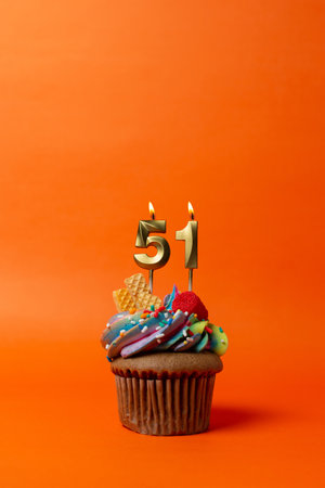 birthday cake with number 51 - cupcake on orange background with birthday candlesの写真素材
