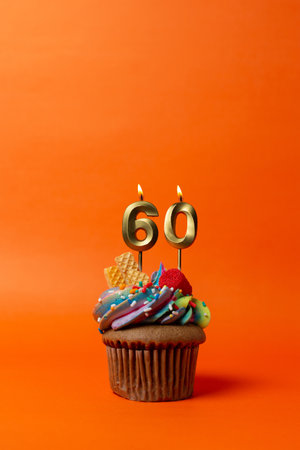 birthday cake with number 60 - cupcake on orange background with birthday candlesの写真素材