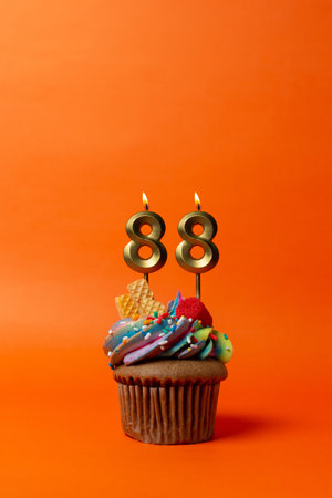 birthday cake with number 88 - cupcake on orange background with birthday candlesの写真素材