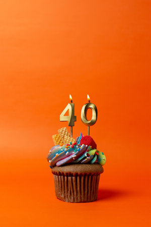 birthday cake with number 40 - cupcake on orange background with birthday candlesの写真素材