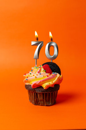 birthday cake with number 70 - cupcake on orange background with birthday candlesの写真素材