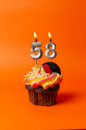 birthday cake with number 58 - cupcake on orange background with birthday candlesの写真素材
