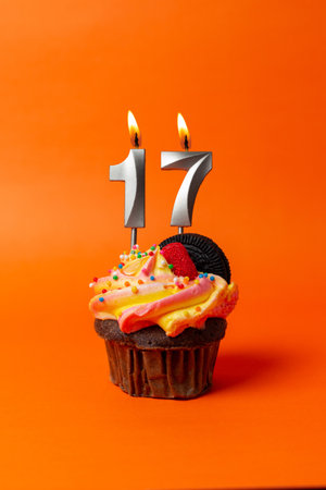birthday cake with number 17 - cupcake on orange background with birthday candlesの写真素材