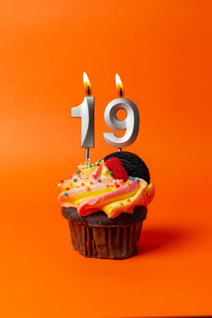 birthday cake with number 19 - cupcake on orange background with birthday candlesの写真素材
