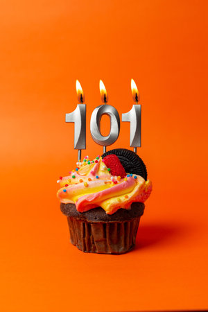 birthday cake with number 101 - cupcake on orange background with birthday candlesの写真素材