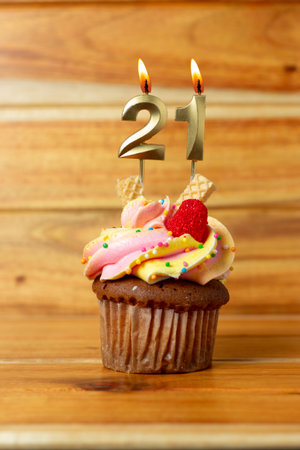 Golden birthday candle on wooden background - Birthday cupcake with numbered candleの写真素材