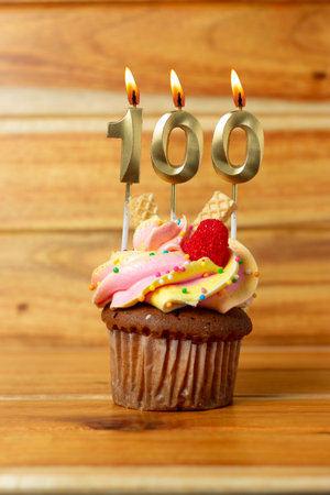 Golden birthday candle on wooden background - Birthday cupcake with numbered candleの写真素材