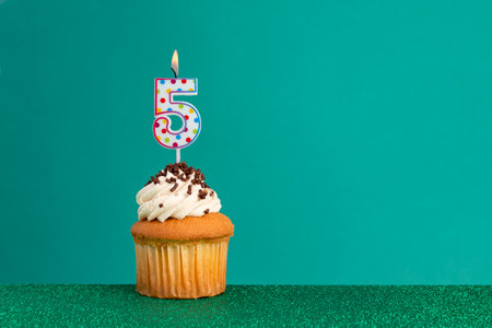 CupCake on bright green and flat green - Birthday candles with colorful dotsの写真素材