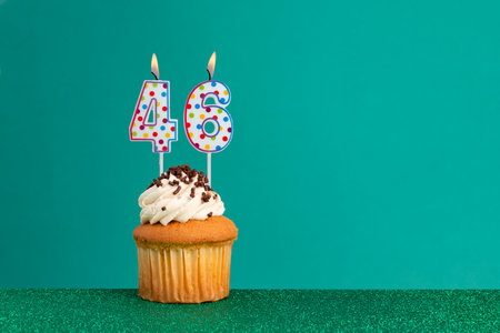 CupCake on bright green and flat green - Birthday candles with colorful dotsの写真素材