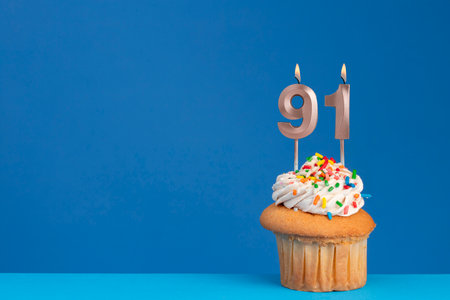 Birthday cupcake on blue background - pink birthday candle numberの写真素材
