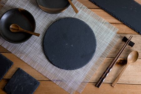 Table Set with stone and wooden plates and utensils on wooden topの写真素材
