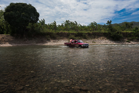 Truck in the middle of the water as it crosses river.の写真素材