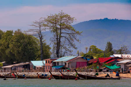 Longtail boats docked along the shore.の写真素材
